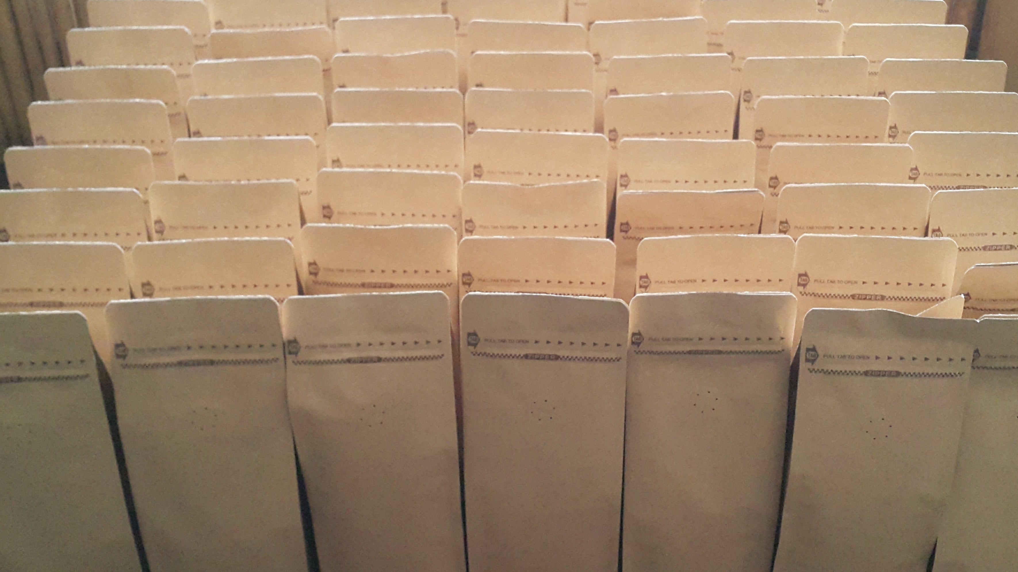 Stack of beige boxes on a wooden surface with a metal stand.